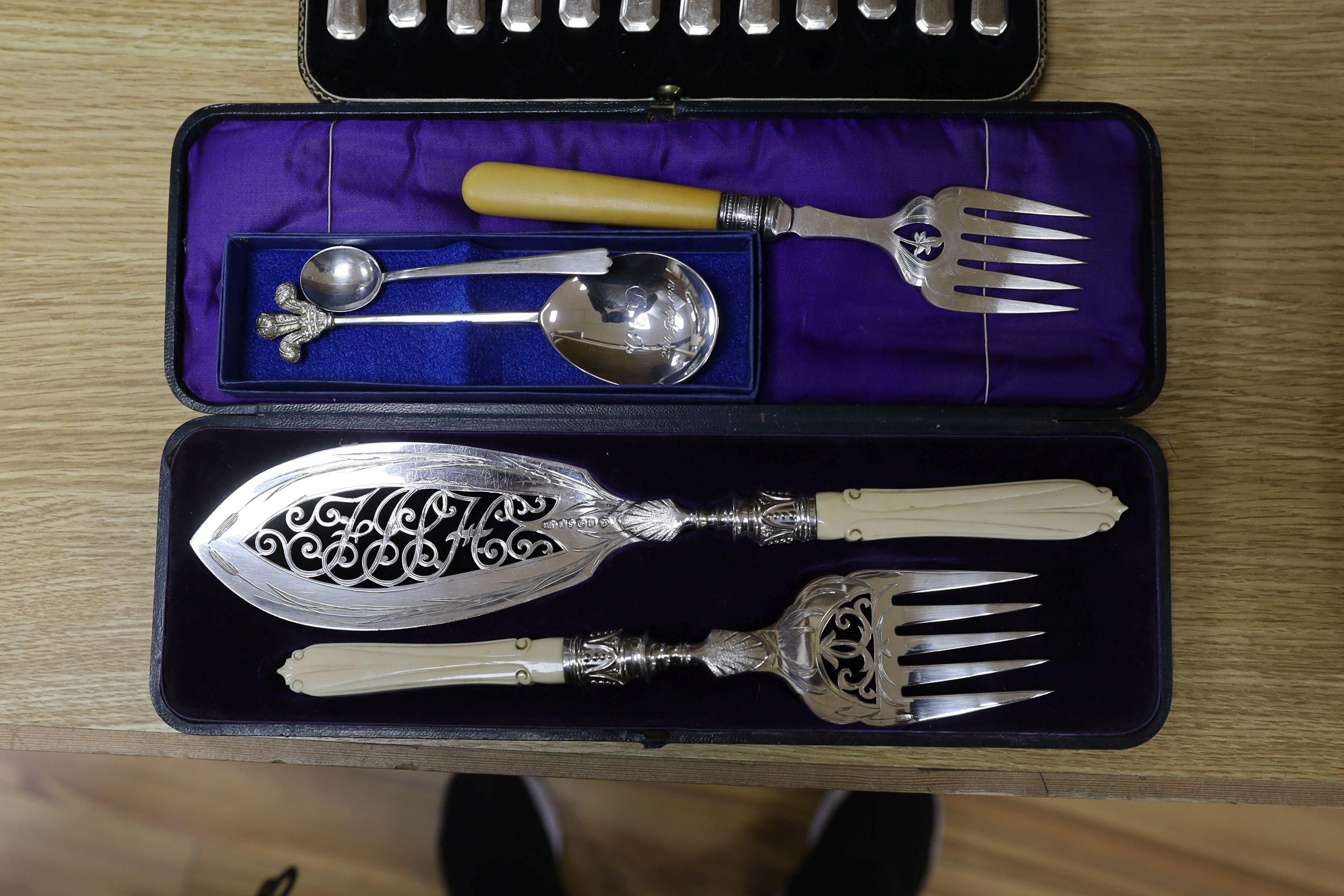 A cased pair of servers, and serving fork, cased silver coffee spoons, royal commemorative spoon, trefid coffee spoon, plated set of dessert knives and forks